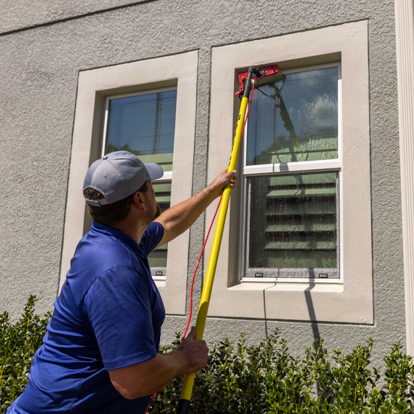 a person using a squeegee to clean a window
